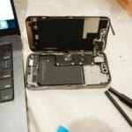 Otwarty iPhone z narzędziami do samodzielnej wymiany baterii