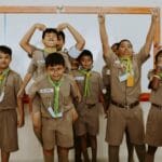 Dzieci w szkolnych mundurkach bawią się razem w klasie podczas lekcji