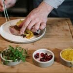 Szef kuchni precyzyjnie układa danie fine dining w nowoczesnej kuchni