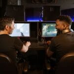 Dwóch mężczyzn gra na PC w nowoczesnym salonie gier